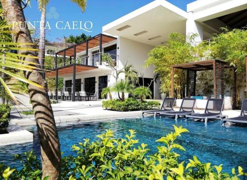 a swimming pool in front of a villa at Charming Zen-style Beach apartment at Punta Caelo in San Carlos