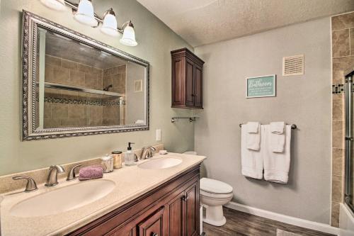 a bathroom with a sink and a toilet and a mirror at Updated Albuquerque Home with Backyard and Grill! in Albuquerque