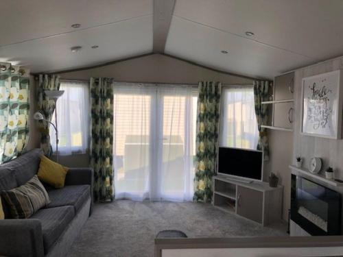 a living room with a couch and a tv at AMETHYST 25 in Whitstable