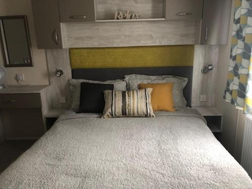a bedroom with a large bed with a yellow headboard at AMETHYST 25 in Whitstable