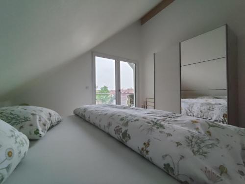 a white room with two beds and a mirror at N13 Living in Wangen im Allgäu