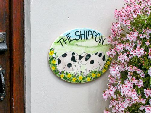 un plato en una pared con una foto de una vaca en The Shippon, en Lympsham