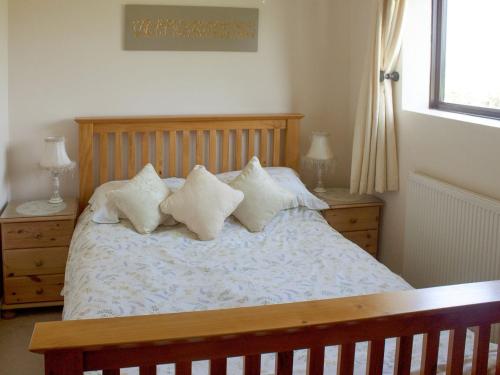 een slaapkamer met een bed met witte lakens en kussens bij The Shippon in Lympsham