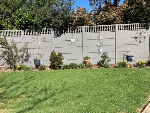 a white fence with some plants in a yard at Time & Again in Ceres