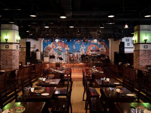 a dining room with tables and a large stage at Nongshim Hotel in Busan