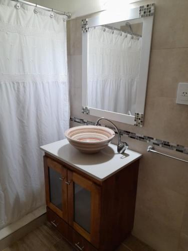 a bathroom with a sink and a mirror on a counter at Cabañas La Lucía in Villa Ventana