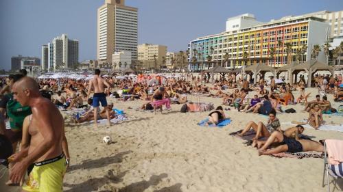 a large crowd of people on a beach at bugrashov 13 room in Tel Aviv