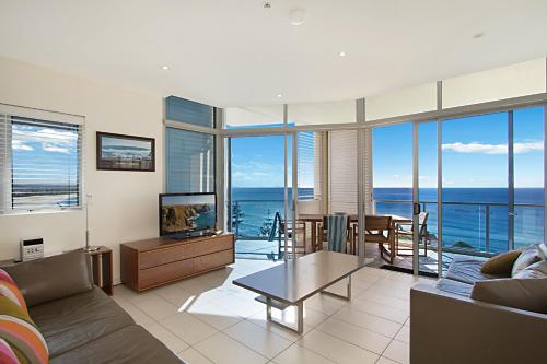 a living room filled with furniture and a large window at Blue C Coolangatta in Gold Coast