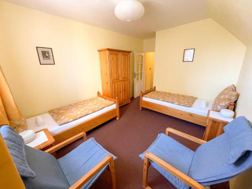 a room with three beds and chairs in it at Ubytování Kubantovi in Prague
