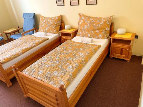 two beds in a room with two night stands and two tables at Ubytování Kubantovi in Prague
