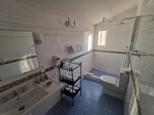 a bathroom with a tub and a toilet and a sink at Hôtel Saint Andre in Saint-Tropez