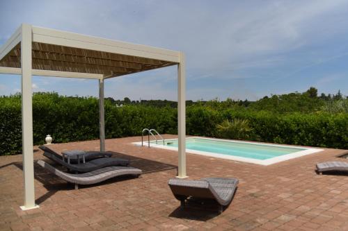 une piscine avec des chaises longues et un pavillon à côté d'une piscine dans l'établissement Trullo delle Querce Suite Private Pool, à Martina Franca