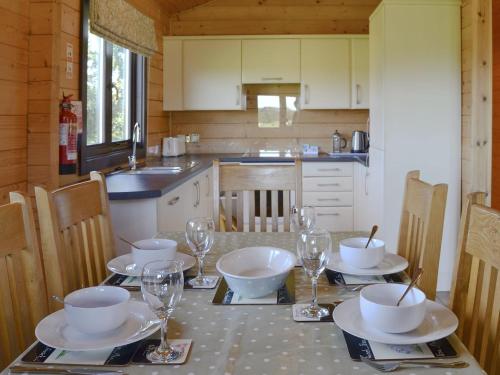 a kitchen with a table with bowls and wine glasses at Dalch - Uk12538 in Witheridge