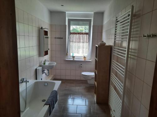 a bathroom with a tub and a toilet and a sink at Villa Affenhaus in Treben