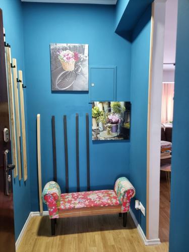 a blue wall with a bench in a room at AryaHome in Bistriţa