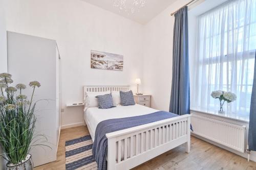 a white bedroom with a bed and a window at No2 Ellington Court Apartment in Torquay