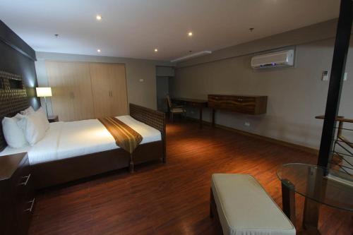 a hotel room with a bed and a desk at Crown Regency Hotel & Towers in Cebu City