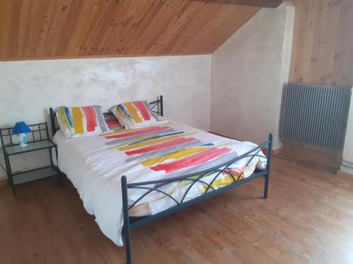 a bed with colorful blankets and pillows in a room at Gite Du Grand Morin in Villeneuve-la-Lionne