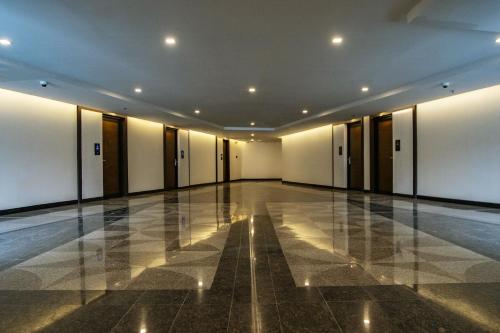 an empty hallway with white walls and a tile floor at Eurobuilding Hotel & Suites Lecheria in El Morro de Barcelona