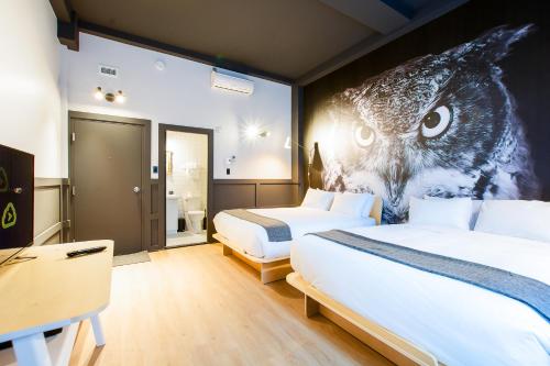 a bedroom with two beds with an owl on the wall at Hôtel du Jardin - Par Les Lofts Vieux-Québec in Quebec City