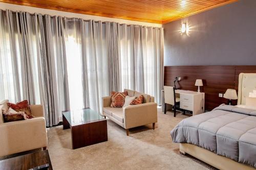 ein Schlafzimmer mit einem Bett und ein Wohnzimmer in der Unterkunft EZRA BOUTIQUE Hotel By The Weekender Ltd in Kigali