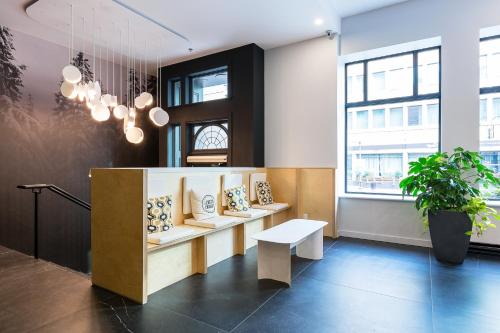 a lobby with a bench and a potted plant at Hôtel du Jardin - Par Les Lofts Vieux-Québec in Quebec City