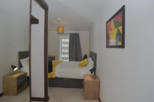 a bedroom with a bed and a mirror at Modern, 2-bedroom Central Southend flat,9th Floor in Southend-on-Sea