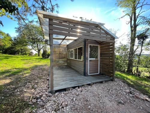 Uxeau的住宿－La Cabane Du Champ Du Possible，一个带甲板的小型木屋