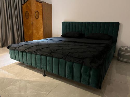 łóżko z zielonym zagłówkiem w sypialni w obiekcie APARTMENT 27 Old City w Bukareszcie