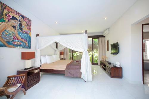 a bedroom with a bed with a canopy at Villa Penelopy in Seminyak