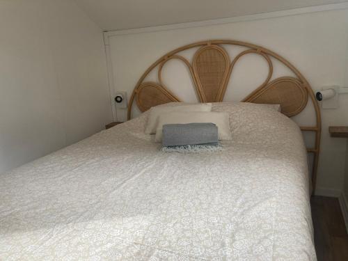 een bed met een houten hoofdeinde met een boek erop bij Le cottage de Christine in Vresse-sur-Semois