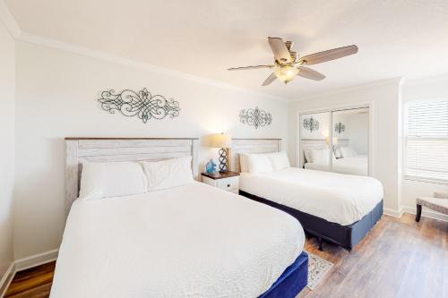 1 dormitorio con 2 camas y ventilador de techo en Island Echoes 1F, en Fort Walton Beach