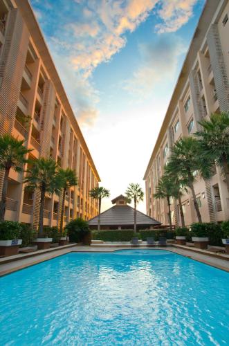 a large swimming pool between two tall buildings at The Ninth Place Serviced Residence in Bangna
