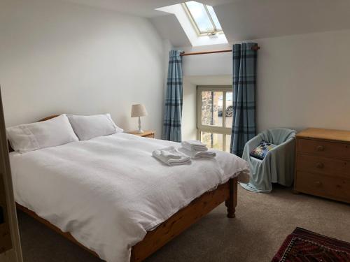 1 dormitorio con 1 cama, vestidor y ventana en The Steading at Pitmeadow Farm en Dunning