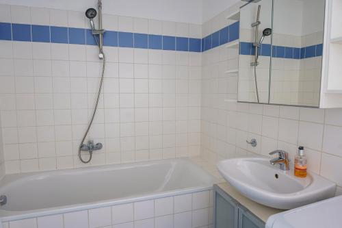 Vienna Living Apartments - Hödlgasse في فيينا: حمام مع حوض استحمام ومغسلة