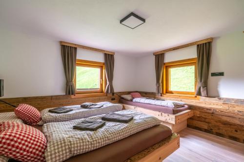 two beds in a room with two windows at Sonnentalhof in Itter