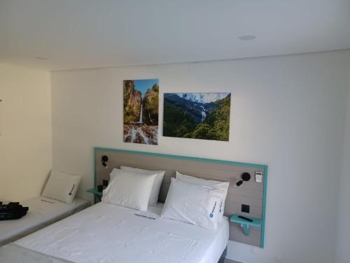 1 dormitorio con 1 cama con 2 cuadros en la pared en Waterfalls Gerês AL, en Gerês