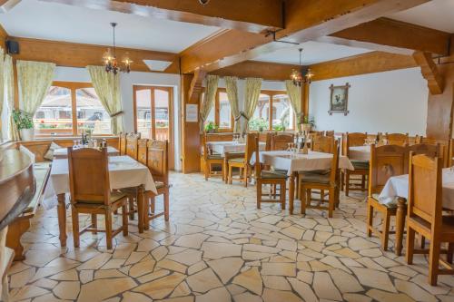 - un restaurant avec des tables et des chaises dans une salle dans l'établissement Popasul Craiului, à Zărneşti