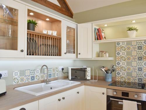 cocina con fregadero y microondas en Calf House Cottage en Sedgefield