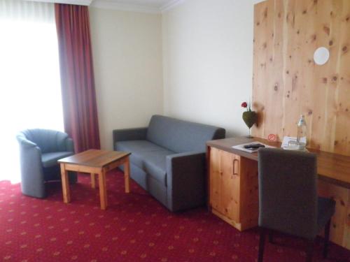 a living room with a couch and a table at Hotel Erlebniswelt Stocker in Schladming