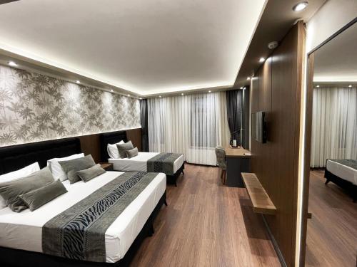 een hotelkamer met 2 bedden en een televisie bij GRAND ÜSKÜDAR OTEL in Istanbul