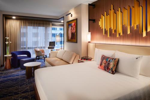 a hotel room with a bed and a living room at Hard Rock Hotel New York in New York