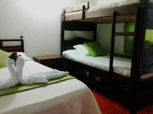 a bedroom with two bunk beds with white sheets at Hospedería Villa Lucía in Villa de Leyva