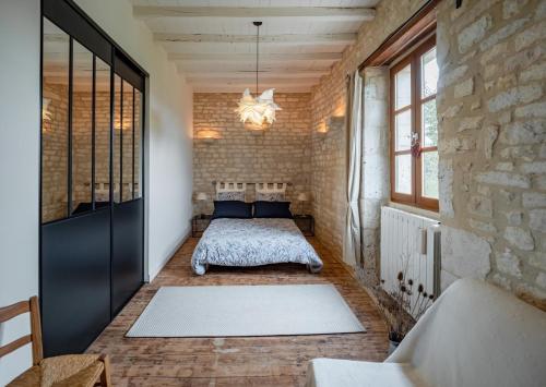 a bedroom with a bed in a brick wall at Chambre d'hôtes l'Hermione in Villeneuve-sur-Vère