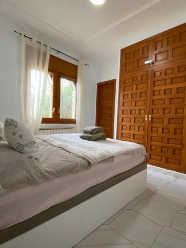 1 dormitorio con 1 cama grande y puertas de madera en Casa Manuela, en Miami Platja