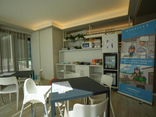 a dining room with two tables and white chairs at Nautilus Family Hotel in Pesaro