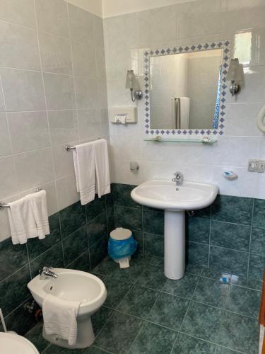 a bathroom with a sink and a toilet and a mirror at Hotel Miramare Garzia in Marinella di Selinunte