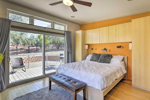 - une chambre avec un lit et une porte coulissante en verre dans l'établissement Sleek, Modern Sedona Home with Rock Views and Hot Tub!, à Sedona