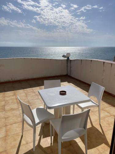 a white table and chairs on a balcony with the ocean at Hotel Miramare Garzia in Marinella di Selinunte