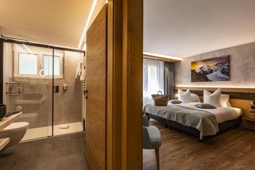 a hotel room with a bed and a bathroom at Hotel Hemizeus & Iremia Spa in Zermatt